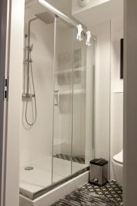 a shower with a glass door in a bathroom at Apartament Leśny No 4 Blue in Kielce