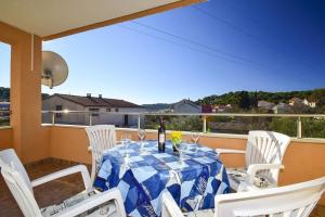 a table with a blue and white table cloth on a balcony at Apartment Luna in Tisno