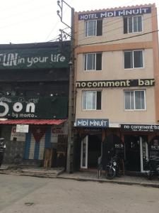 a building on a street with a motorcycle parked in front at Midi Minuit in Antananarivo
