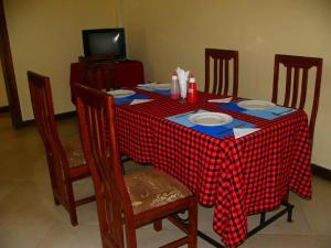 a table with a red and white checkered table cloth at Bright Star Hotel in Arusha