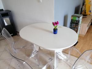 a white table with a vase with flowers on it at Apartment Luna in Tisno +1 photo