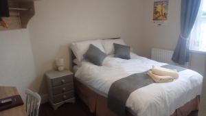 a small bedroom with a bed and a night stand at The Victoria guest house in Mablethorpe