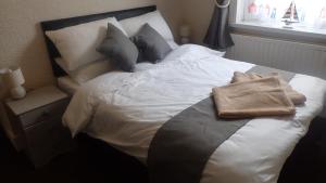 a white bed with pillows and a towel on it at The Victoria guest house in Mablethorpe