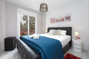 1 dormitorio con 1 cama grande con manta azul en 4 Bedroom apartment in Puerto Banus 150 meters from the beach, en Marbella