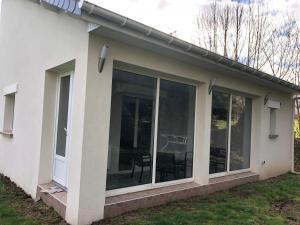 eine abgeschirmte Veranda eines Hauses mit Glastüren in der Unterkunft Gîte vickie in Livry