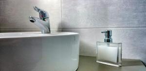 a bathroom sink with a faucet and a glass container at Anima Apartments in Chora Folegandros