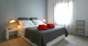 a bedroom with a bed with red towels on it at Anima Apartments in Chora Folegandros
