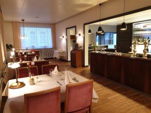 a restaurant with a table and chairs and a bar at Hotel Hessischer Hof in Melsungen