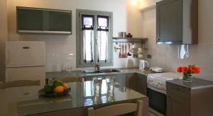 a kitchen with a table with a bowl of fruit on it at Anima Apartments in Chora Folegandros +28 photos
