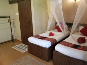 two beds in a room with red pillows at Ombak Dive Resort Perhentian Island in Perhentian Islands