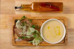 a sandwich and a bowl of soup and a bottle of wine at Hotel Rodan in Kórnik