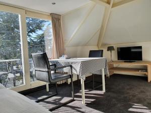 een kamer met een tafel en twee stoelen en een televisie bij De Wentehoeve in Oostkapelle