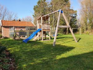 a playground with a blue slide in a yard at De Wentehoeve in Oostkapelle