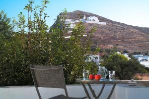 a table and chair with a view of a hill at Anima Apartments in Chora Folegandros