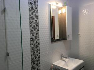 a bathroom with a sink and a mirror and a shower at Hotel Mirazh in Yessentukskaya