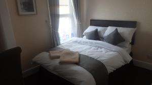 a bedroom with a large bed with a window at The Victoria guest house in Mablethorpe