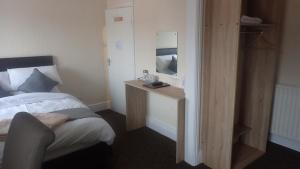 a hotel room with a bed and a wooden table at The Victoria guest house in Mablethorpe