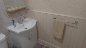 a white bathroom with a sink and a towel at The Victoria guest house in Mablethorpe