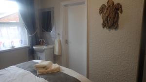 a bedroom with a bed with towels on it at The Victoria guest house in Mablethorpe