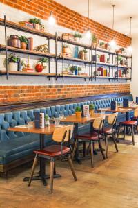 a restaurant with wooden tables and chairs and a brick wall at Saint Pauls House in Birmingham