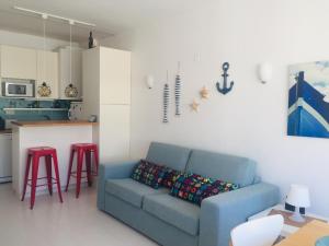 Una sala de estar con un sofá azul y una cocina. en Armação de Pêra - Beach Apartment - Sea View- Walk to the Beach - Algarve, en Armação de Pêra 12 fotos más