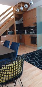 a kitchen with wooden cabinets and a table and chairs at Grand Paradise Apartman in Miskolc