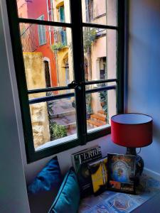 a window with a red lamp in a room at Maison de Ville typique Mentonnaise in Menton
