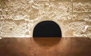 a room with a wooden table and a stone wall at Trulli e Puglia Luxury Suite in Alberobello
