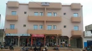 巴马科IMMEUBLE KCF的一座粉红色的大建筑,前面的人