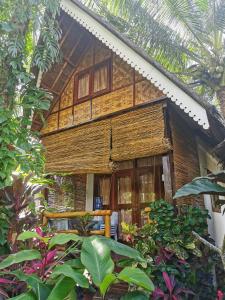 ein Holzhaus inmitten eines Gartens in der Unterkunft Latitude 10 Siargao in General Luna