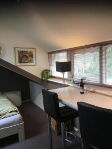 a room with a desk and a bed and windows at B n B nr. 1 in Apeldoorn