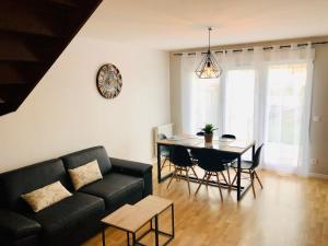 a living room with a black couch and a table at happiness Disney in Saint-Germain-sur-Morin