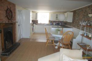 a kitchen and living room with a table and chairs at Splash Cottage, Bangor, Co Down in Bangor