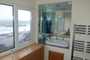 a bathroom with a sink and a large window at Splash Cottage, Bangor, Co Down in Bangor