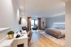 ein Hotelzimmer mit einem Bett und einem Schreibtisch in der Unterkunft Antunović Hotel East in Sesvete