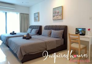 um quarto com 2 camas, uma secretária e uma cadeira. em Inspired Homes @ Summer Suite em Kuala Lumpur