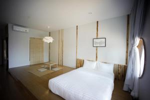 楠府的住宿－HOMU Villa Pua，卧室配有白色的床和窗户。