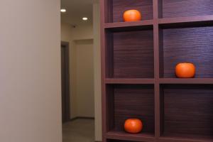 two oranges sitting on a wooden book shelf at MANDARIN Hotel in Yerevan