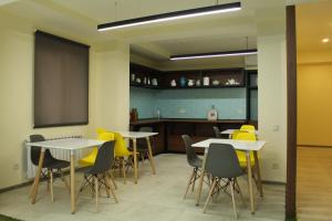 a classroom with tables and yellow chairs and a chalkboard at MANDARIN Hotel in Yerevan