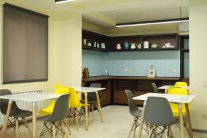a dining room with tables and yellow chairs at MANDARIN Hotel in Yerevan