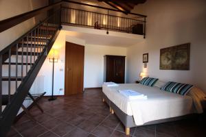 a bedroom with a large bed and a staircase at Agriturismo Verbena in Castiglione del Lago