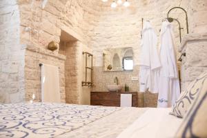 a bedroom with a large bed and a bathroom at Trulli e Puglia Luxury Suite in Alberobello