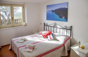 a bedroom with a bed with towels on it at Casa Delta delle Acque Vista spettacolare e Giardino in Cala Gonone