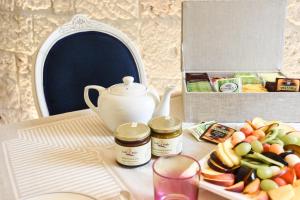 a table with a tea pot and a plate of food at Trulli e Puglia Luxury Suite in Alberobello