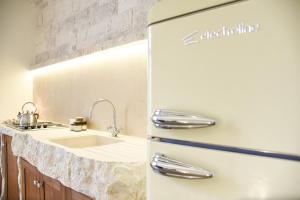 a white refrigerator in a kitchen with a sink at Trulli e Puglia Luxury Suite in Alberobello