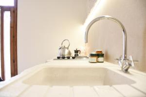 a kitchen sink with a tea kettle on a counter at Trulli e Puglia Luxury Suite in Alberobello