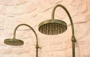 two green water faucets hanging on a wall at Trulli e Puglia Luxury Suite in Alberobello