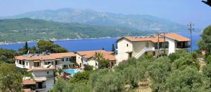 una casa su una collina con vista sull'acqua di Ino Village Hotel a Samos