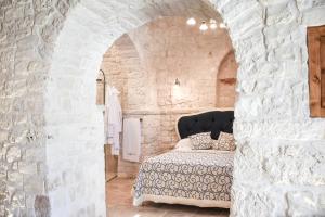 a bedroom with a bed in a stone wall at Trulli e Puglia Luxury Suite in Alberobello