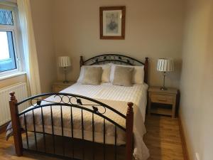 una camera da letto con letto, lenzuola e cuscini bianchi di Atlantic View House a Killybegs